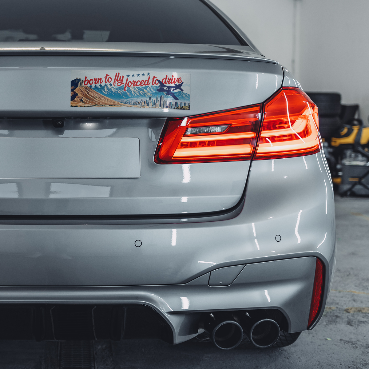 Born_to_fly_forced_to_drive_bumper_stick_ClearBumperSticker_GrayCar_Mockup.png_15837402